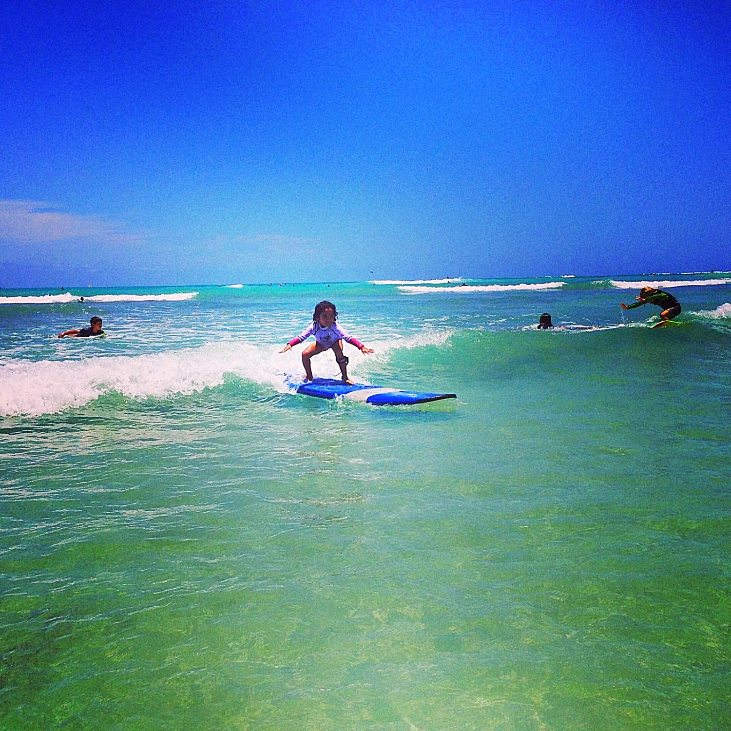 A surfer enjoying a wave in the clear waters of the North Shore